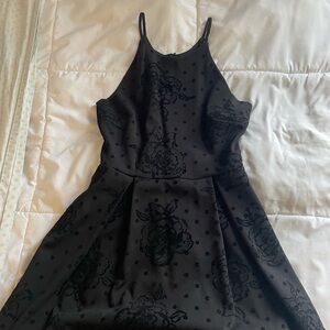 Black short dress, floral detailing.